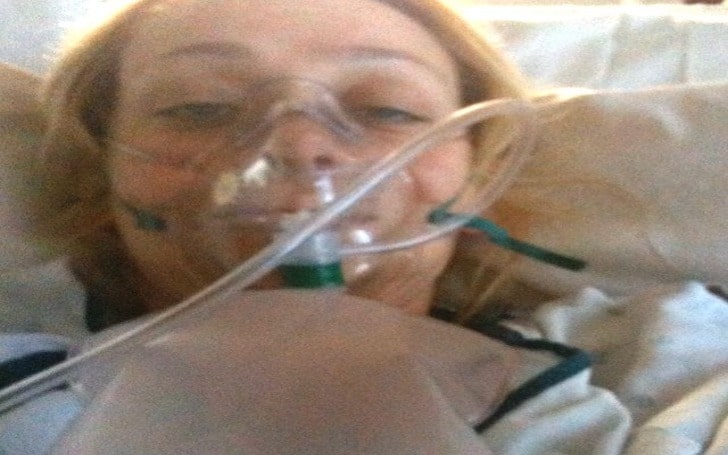 Nicole Sullivan wearing an oxygen mask in an ICU room.